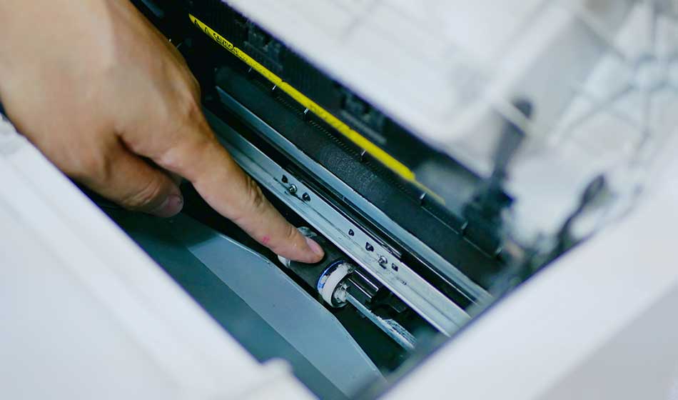 A Finger Pointing At Spilled Black Toner Powder Inside The Printer